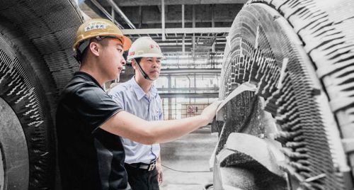 Service Engineer Jake Li from Valmet (left) and Production Manager Yichang Zhong inspect the CD segment holder.
