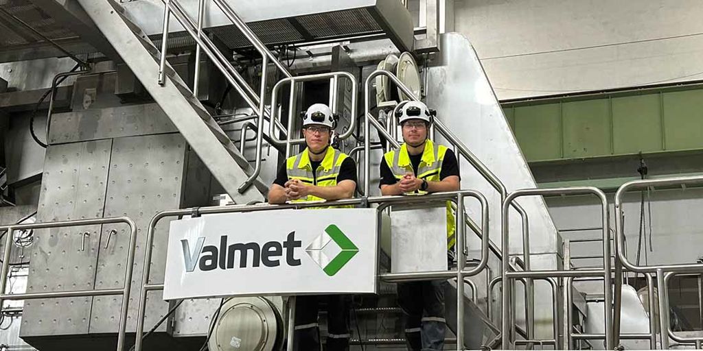 Valmet PRO trainees, Aapo and Jonne standing in front of a Valmet paper machine 