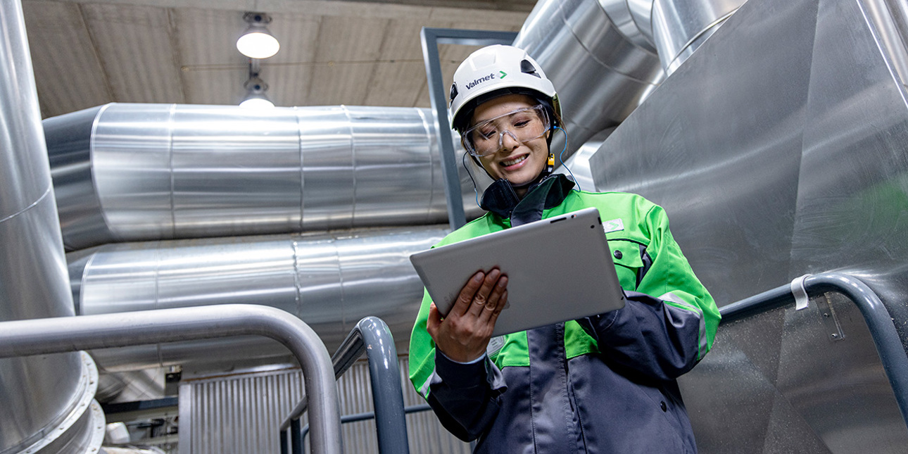 A person inside a factory holding a tablet