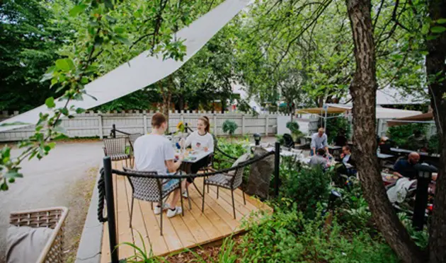 Two people eating on a garden terrace