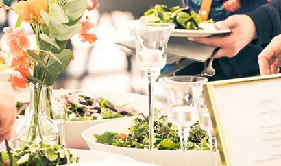A person taking food at a buffet table