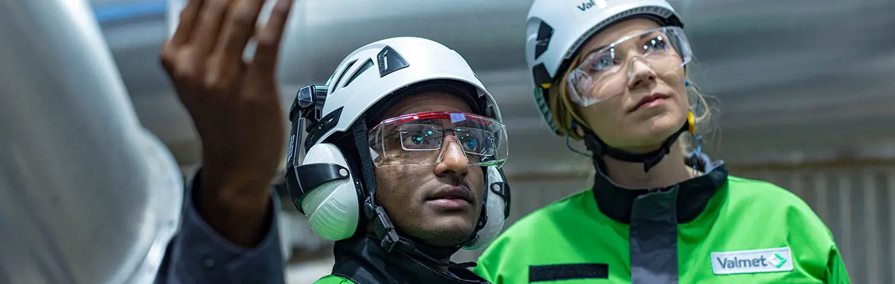 Two Valmet employees looking up while working on-site