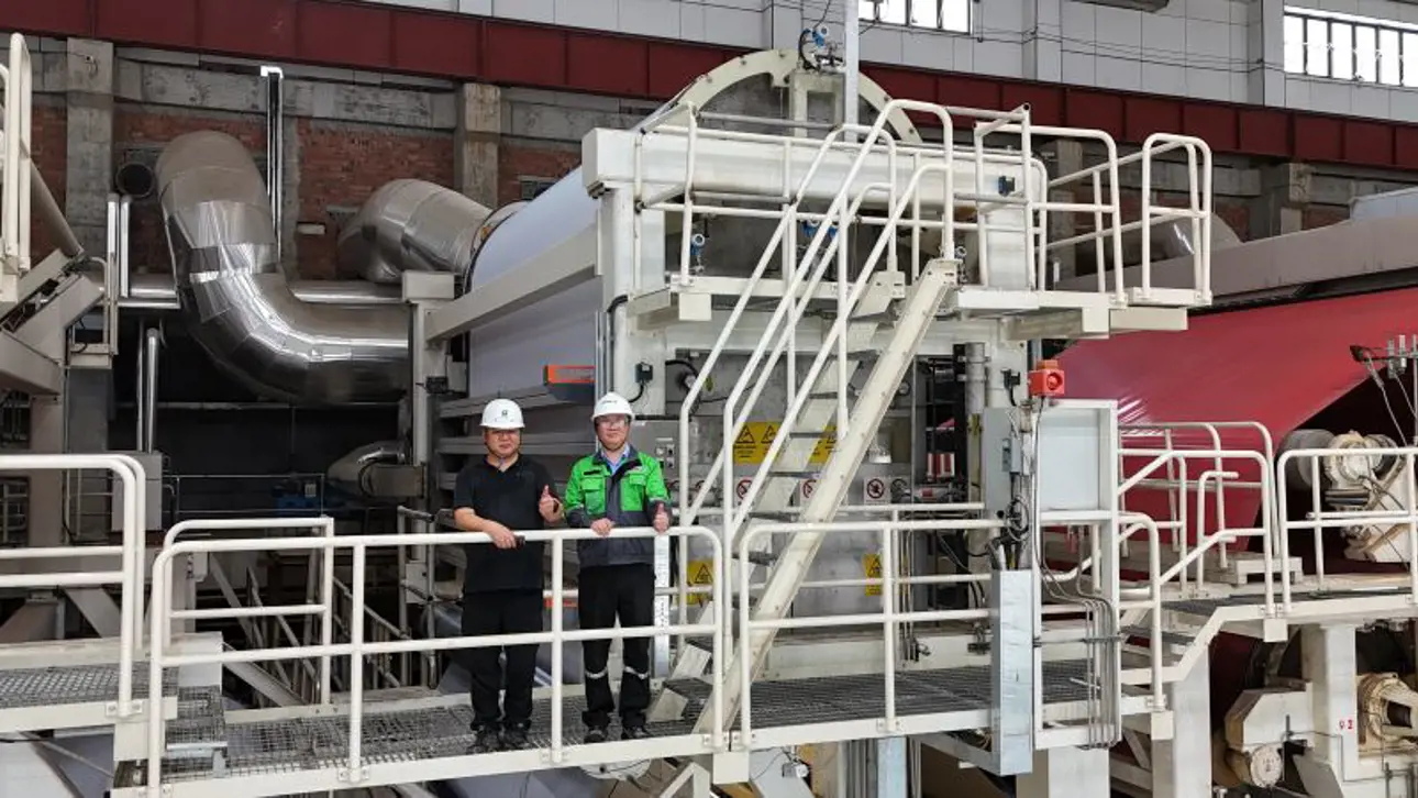 Two people in front of an OptiDry Coat double-pass showing thumbs up
