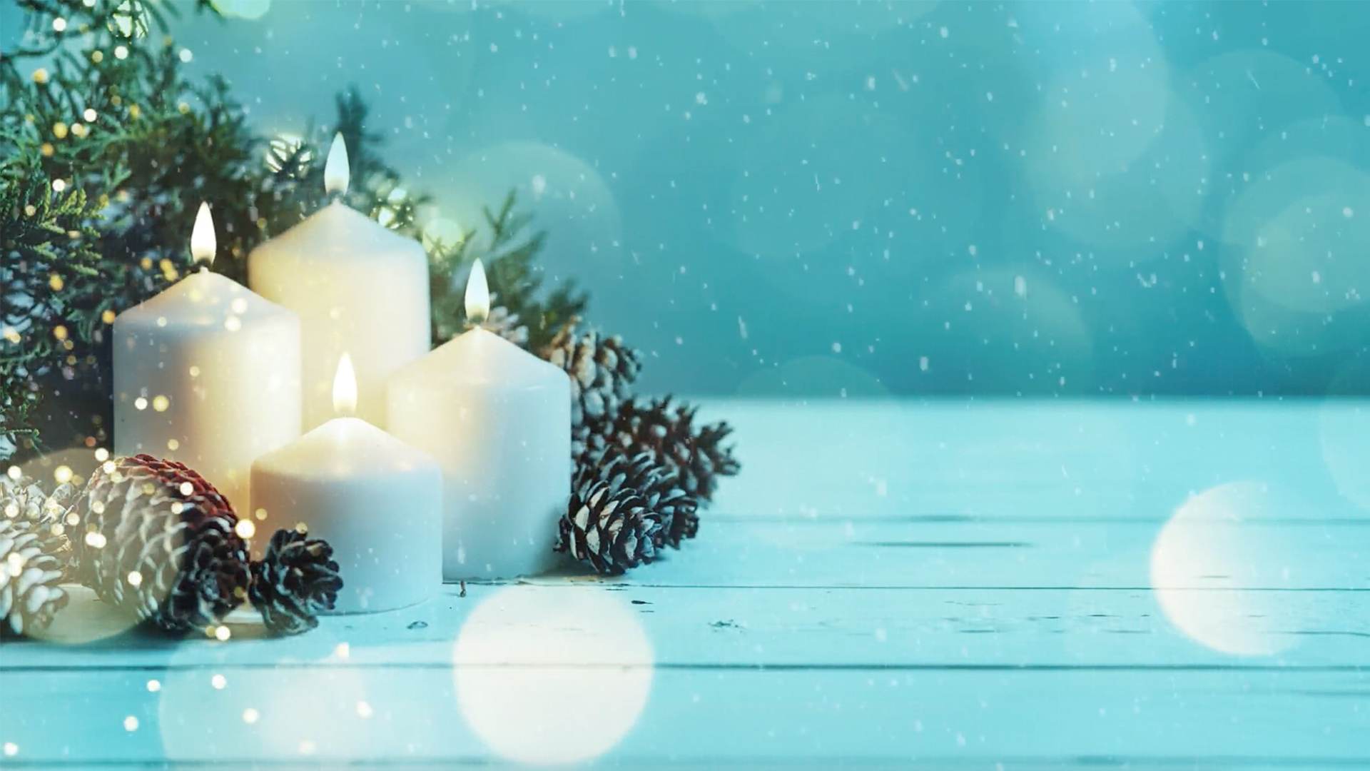 Four white candles are lit and arranged on a snowy surface, surrounded by pinecones and evergreen branches, with softly falling snow and a blue background creating a peaceful, wintery atmosphere.