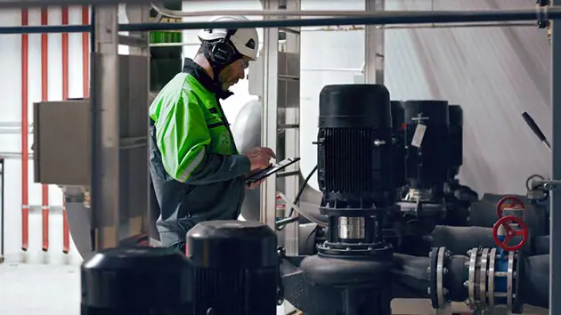Maintenance worker using mobile Valmet DNA Distributed control system (DCS)