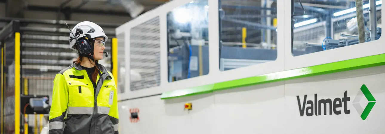 Valmeteers standing next to a molded fiber production line