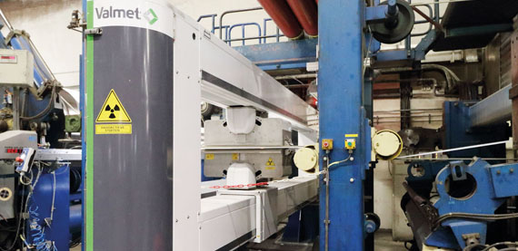 The Valmet IQ Scanner before the reel measures basis weight, moisture, ash and caliper with a single-sided scanner measuring moisture before the glazing cylinder. Machine direction controls include basis weight, moisture, ash, and jet/wire ratio for both headboxes on this two-layer machine.