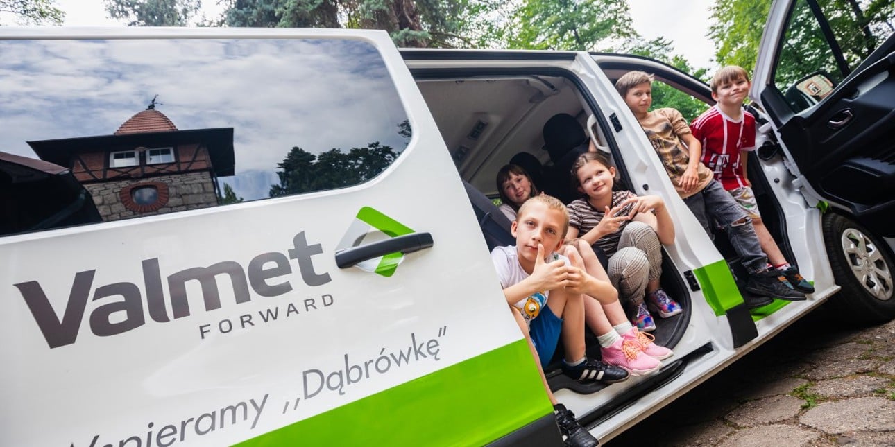 Children sitting in a car with Valmet's logo
