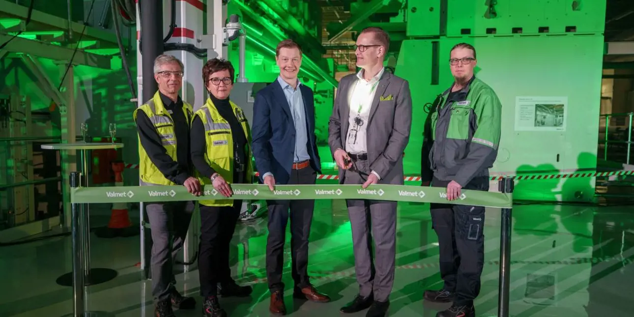 Group of people standing in front of a new needling machine, that was inaugurated in Tampere, Finland.
