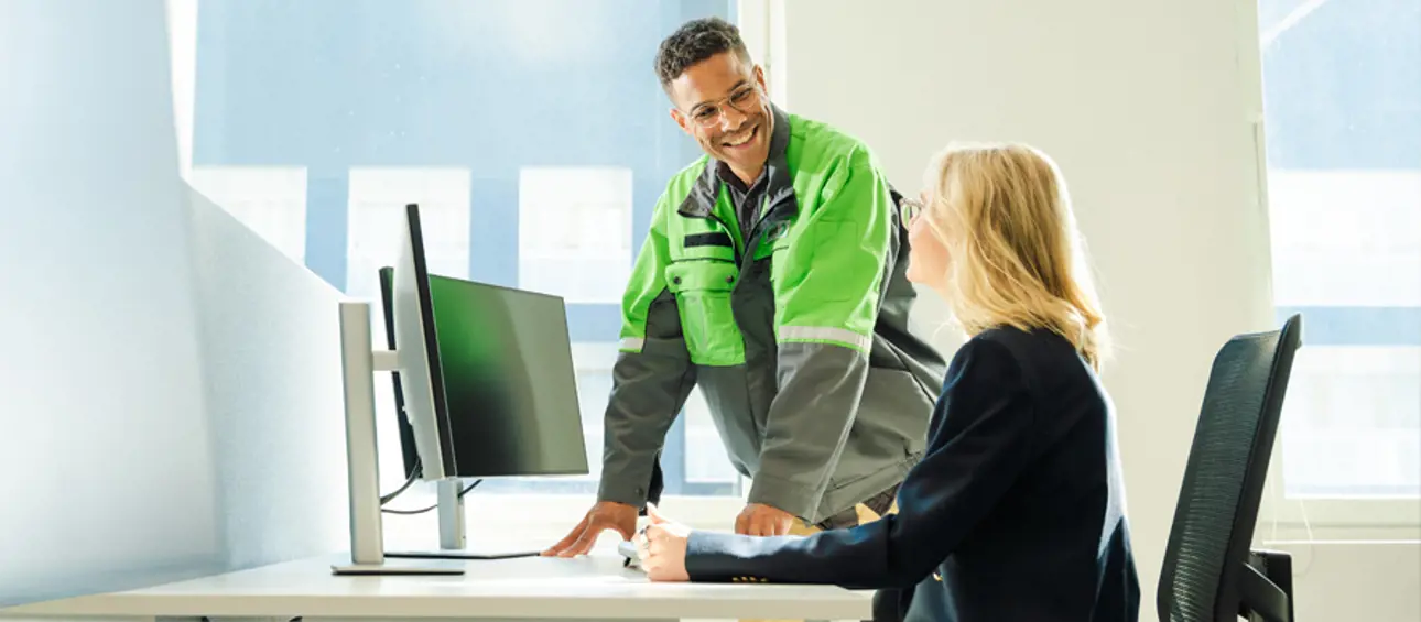 Two people discussing infront of a computer