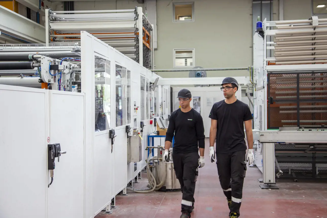 Close-up of rotating rollers and guiding mechanisms inside a high-precision industrial paper converting machine.